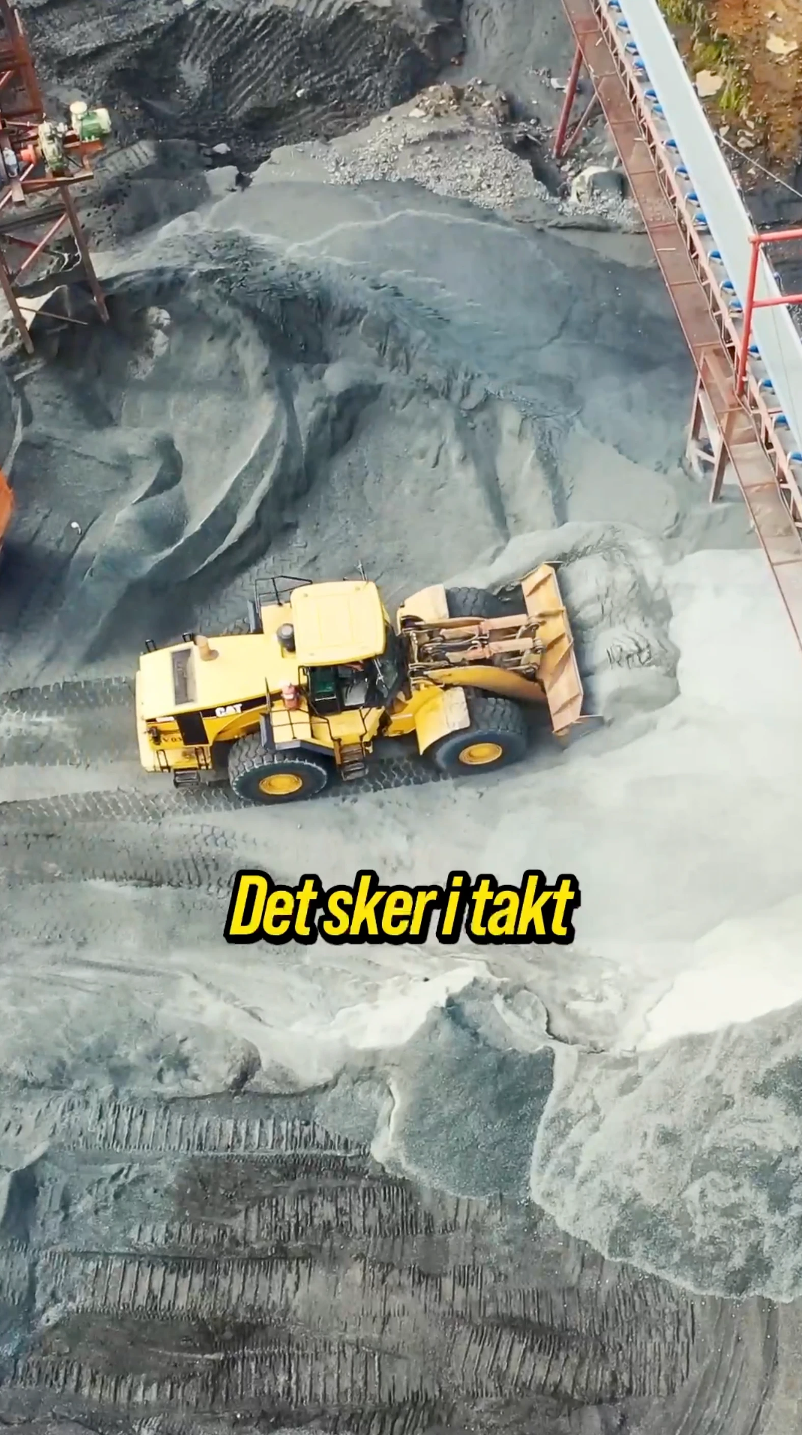 Gul hjullastare på ett grustag med texten ”Det sker i takt”.